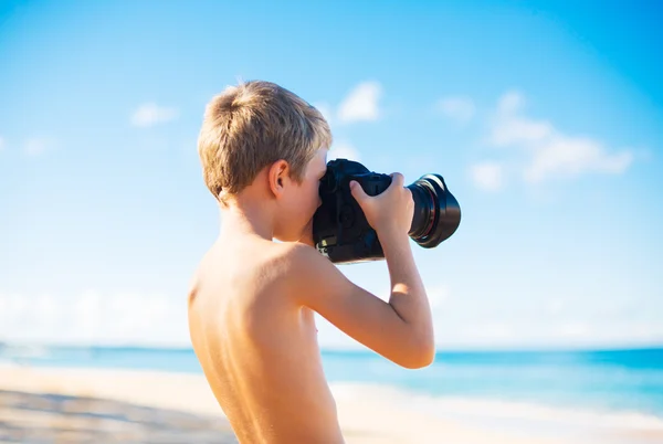 Niño en la playa con cámara — Foto de Stock