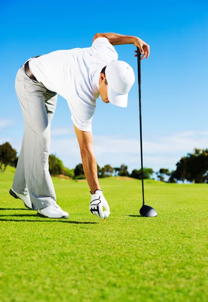 Hombre colocando pelota de golf en la camiseta — Foto de Stock