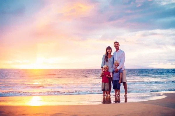 Porträtt av familjen på stranden vid solnedgången — Stockfoto