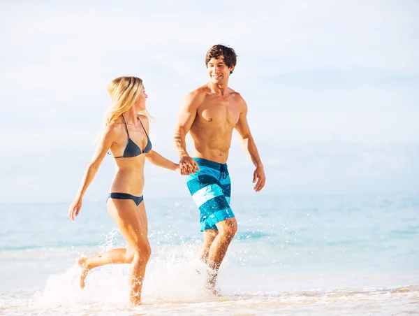 Pareja feliz caminando por la playa — Foto de Stock