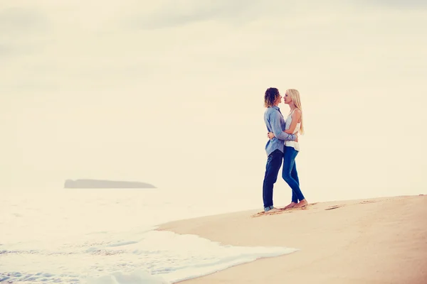 Pareja joven besándose en la orilla del mar — Foto de Stock