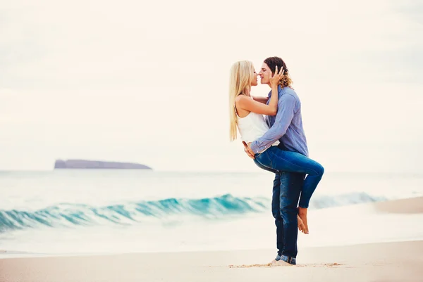 Giovane coppia baciare sulla riva del mare — Foto Stock