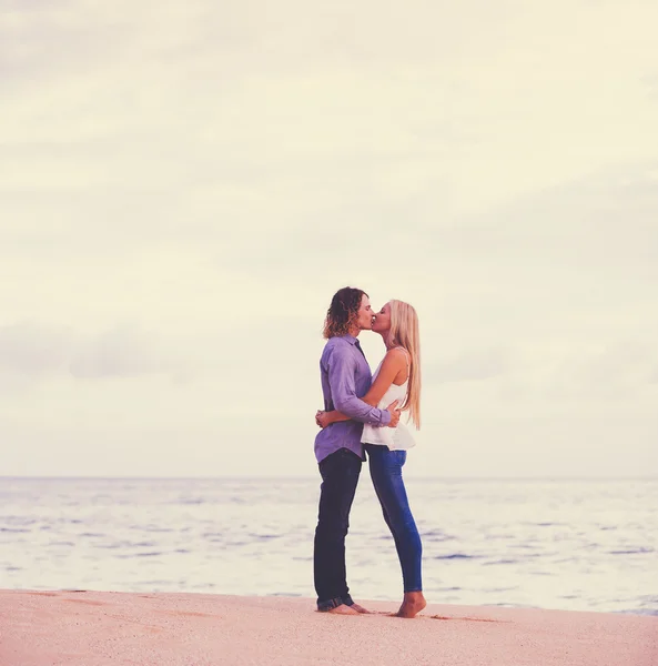 Молодая пара целуется на берегу моря — стоковое фото