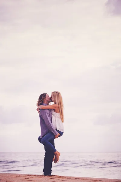Молодая пара целуется на берегу моря — стоковое фото