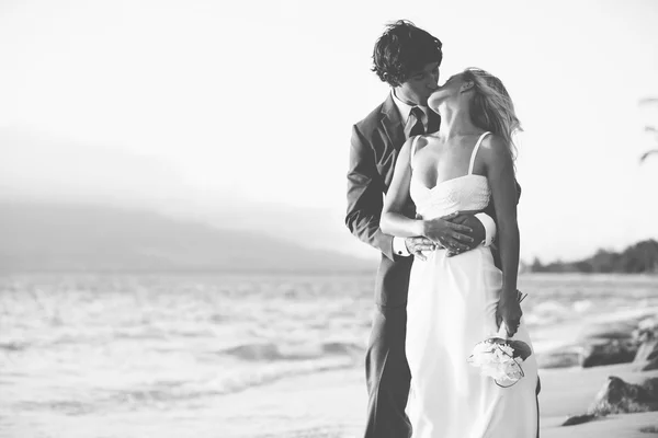 Novia y novio besándose en la playa — Foto de Stock