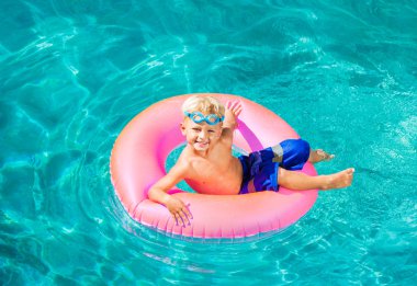 Genç çocuk yüzme havuzunda eğleniyor