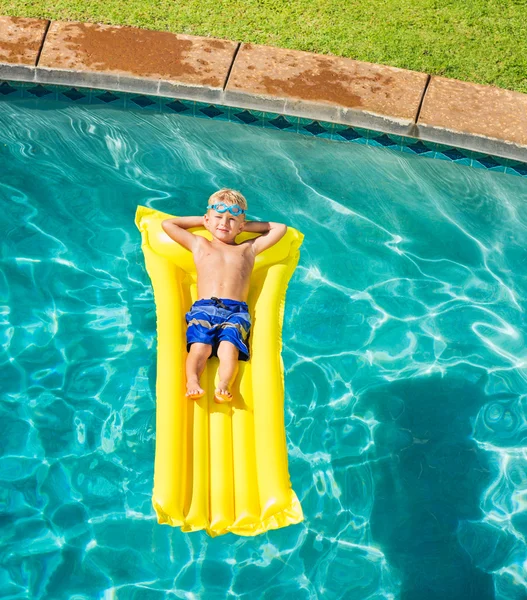 Chlapec, relaxace a zábava v bazénu na žlutý vor — Stock fotografie