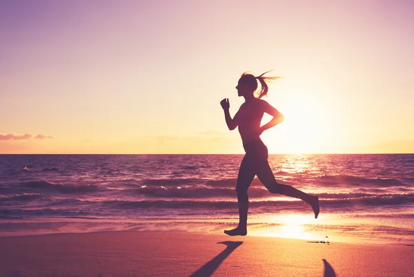 Жінка біжить на заході сонця — стокове фото