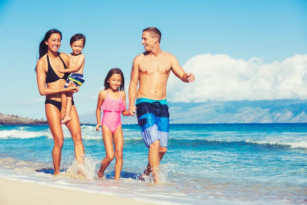 Família feliz se divertindo na praia — Fotografia de Stock
