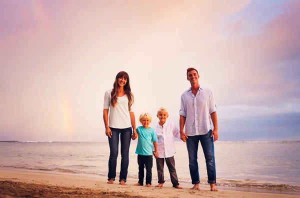 Семья на пляже на закате — стоковое фото