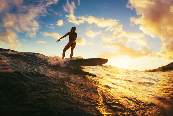 Vrouw surfen bij zonsondergang — Stockfoto