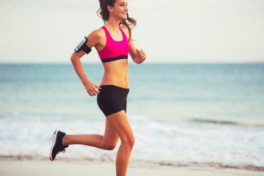 Gün batımında sahilde çalışan spor Fitness kadın