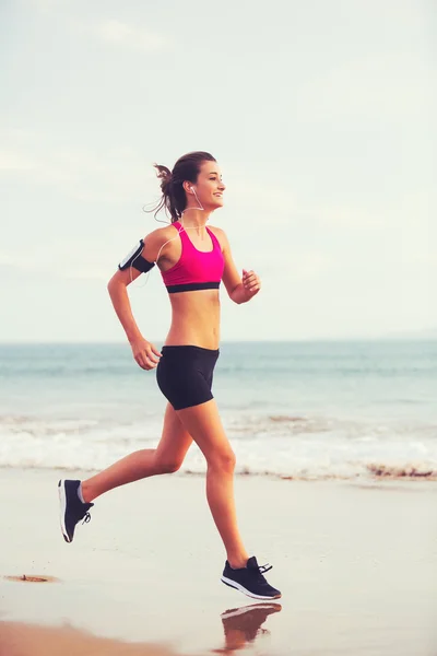 Mujer deportiva corriendo en la playa al atardecer —  Fotos de Stock