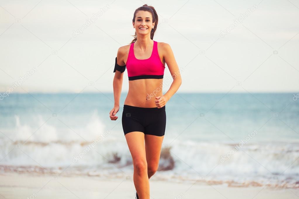 Sports Fitness Woman Running on the Beach at Sunset