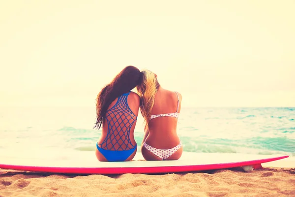 Surfista niñas en la playa al atardecer —  Fotos de Stock