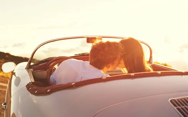Пара поцелуев в классическом винтажном спортивном автомобиле — стоковое фото