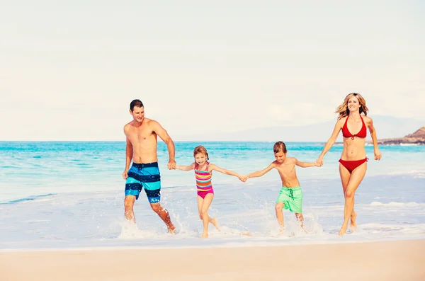 Lycklig familj som har roligt på stranden — Stockfoto