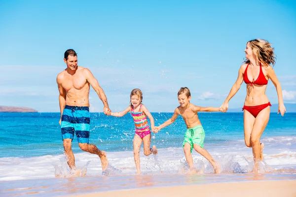 Lycklig familj som har roligt på stranden — Stockfoto