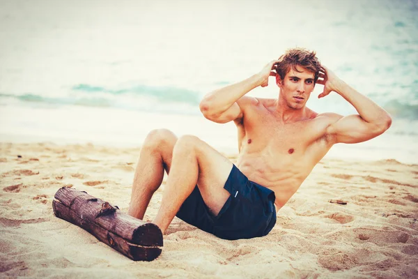 Člověk dělá sit-up venku na pláži — Stock fotografie