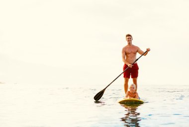 Father and Son Stand Up Paddling clipart