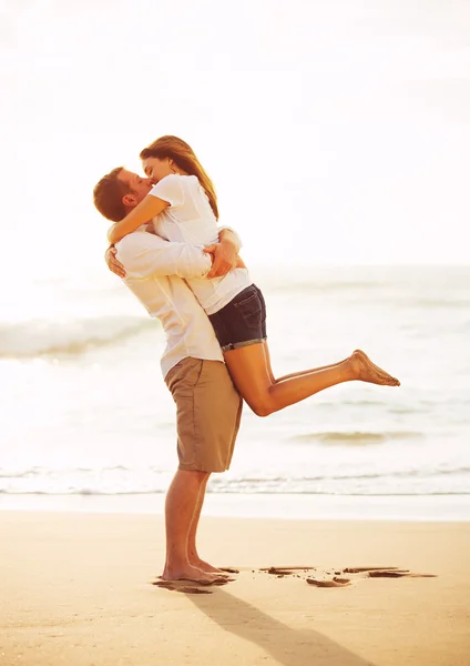 Casal romântico beijando na praia ao pôr do sol — Fotografia de Stock