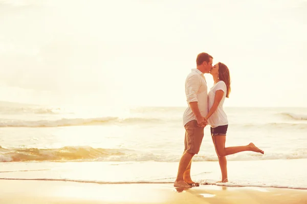 Casal romântico beijando na praia ao pôr do sol — Fotografia de Stock