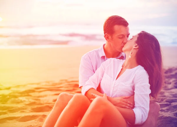 Romantisches Paar genießt schönen Sonnenuntergang am Strand — Stockfoto