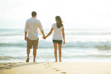 Gün batımında okyanus yürüme Çift