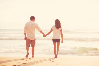 Gün batımında sahilde romantik genç Çift