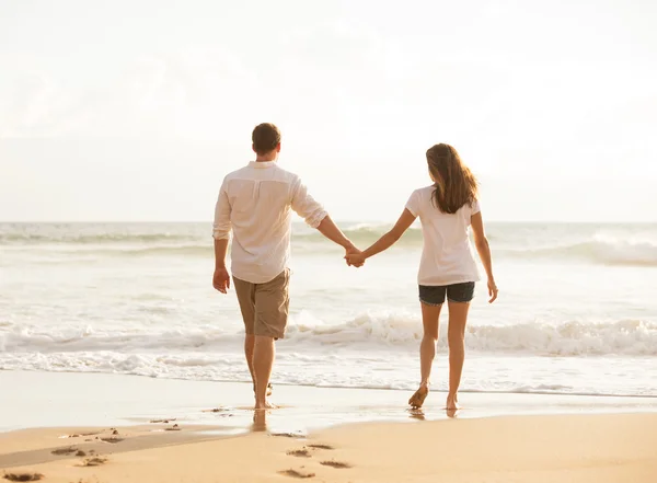Ρομαντικό νεαρό ζευγάρι στην παραλία στο ηλιοβασίλεμα — Φωτογραφία Αρχείου