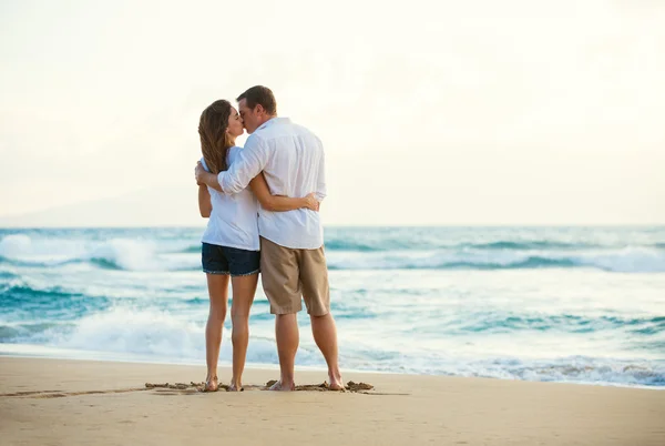 Jeune couple embrasser sur la plage au coucher du soleil — Photo