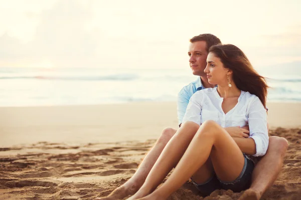 Paar ontspannen op het strand kijken naar de zonsondergang — Stockfoto