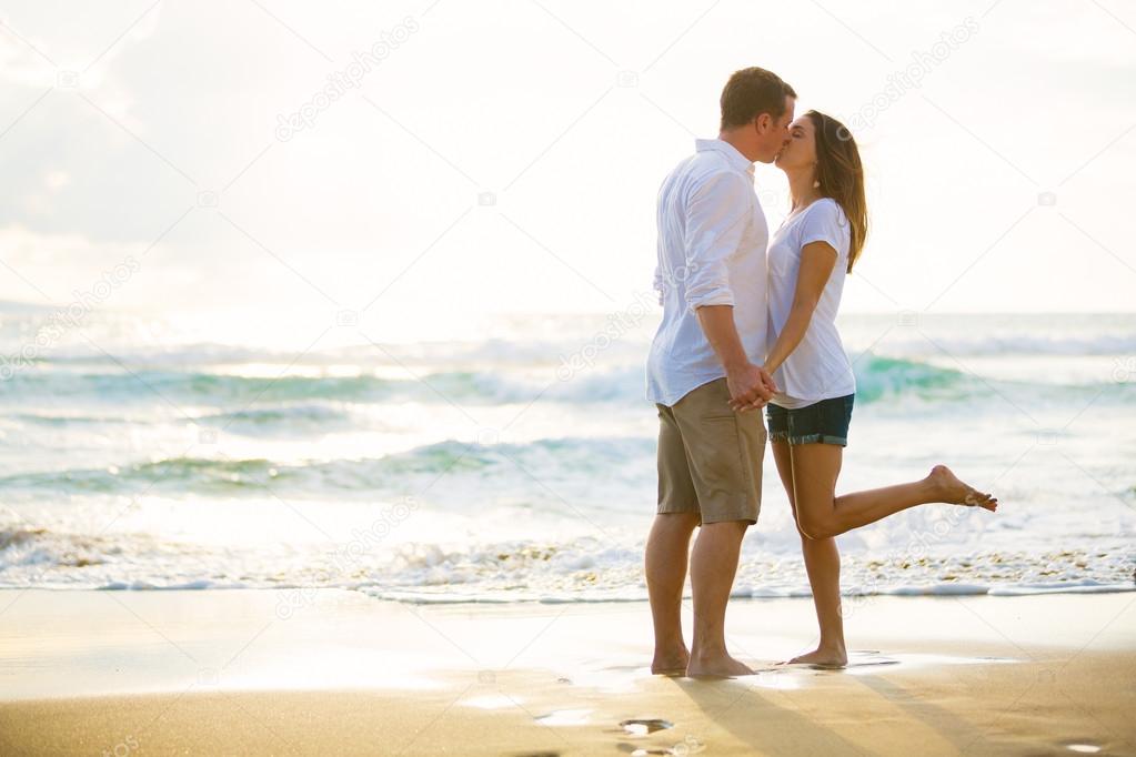 Young Couple Kissing on the Beach at Sunset