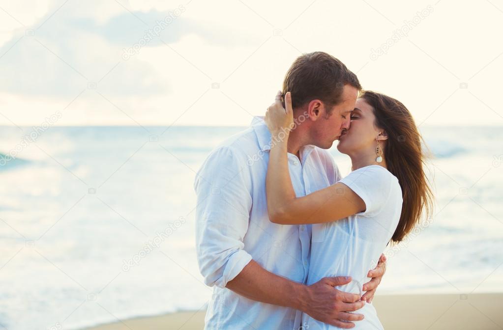 Young Couple Kissing on the Beach at Sunset