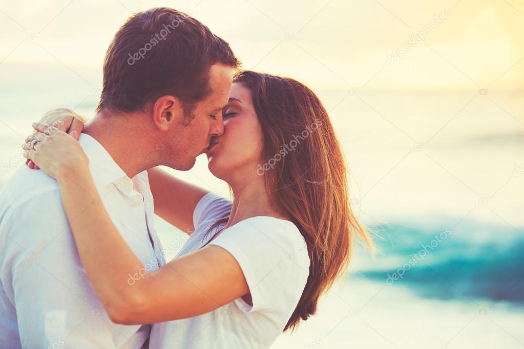 Young Couple Kissing on the Beach at Sunset