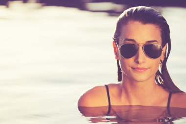 Günbatımı havuzda dinlendirici güzel kadın