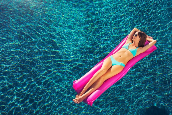 Woman Relaxing Floating on Raft in Pool