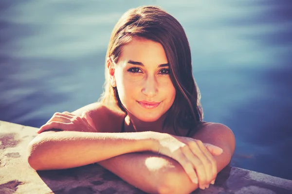 Hermosa mujer relajándose en la piscina al atardecer — Foto de Stock