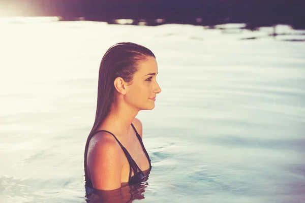 일몰에 수영장에서 편안한 아름 다운 여자 — 스톡 사진