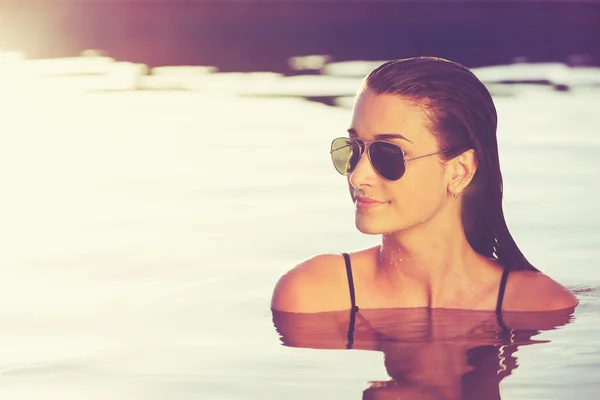 Hermosa mujer relajándose en la piscina al atardecer —  Fotos de Stock