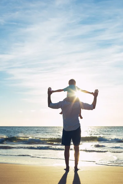 Far och son leker på stranden — Stockfoto