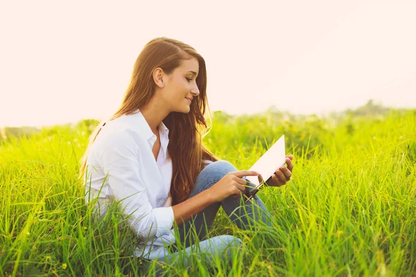 Щаслива молода жінка використовує планшет — стокове фото