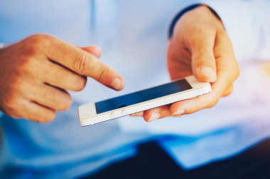 Genç adam akıllı telefon kullanıyor.