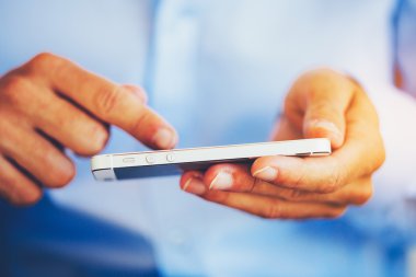 Genç adam akıllı telefon kullanıyor.