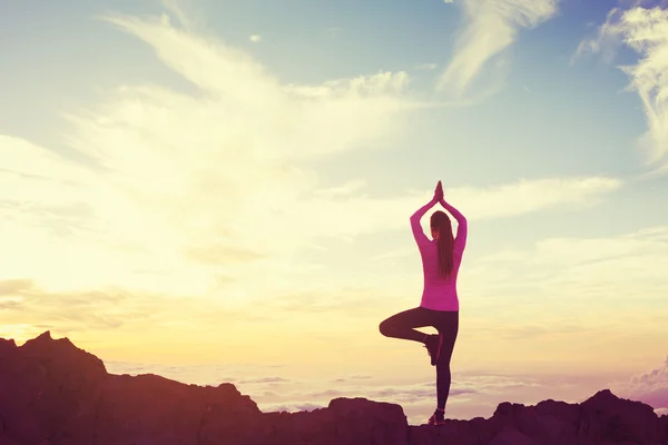 Vrouw beoefenen van Yoga in de bergen bij zonsondergang — Stockfoto