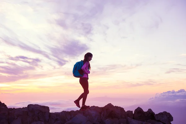 女人在日落时分在山里徒步旅行 — 图库照片