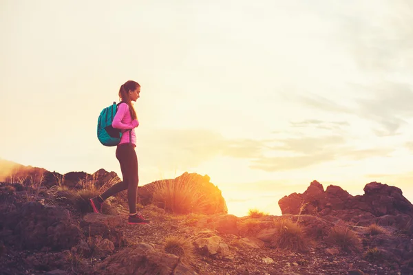 Vrouw wandelen in de bergen bij zonsondergang — Stockfoto