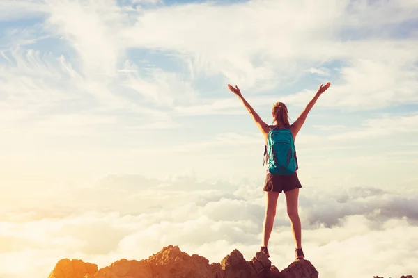 Caminhante feliz mulher com braços abertos ao pôr do sol no pico da montanha — Fotografia de Stock