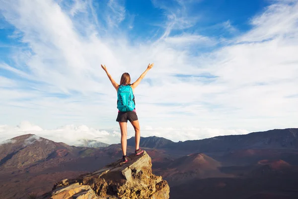 Giovane donna con zaino sulla vetta della montagna a braccia aperte — Foto Stock