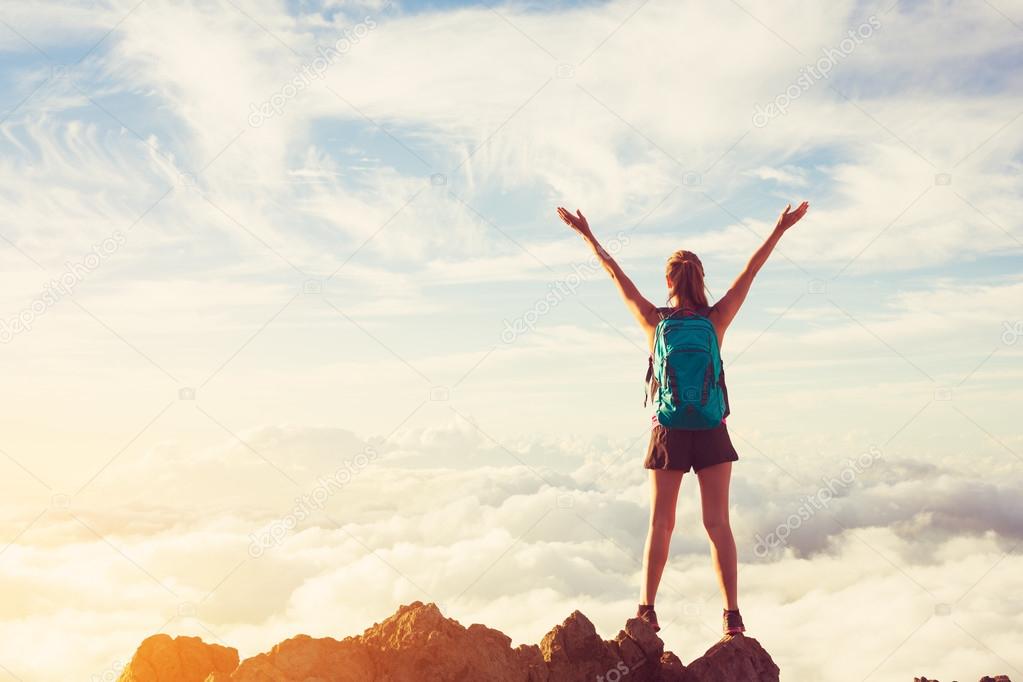 Happy Woman Hiker With Open Arms at Sunset on Mountain Peak